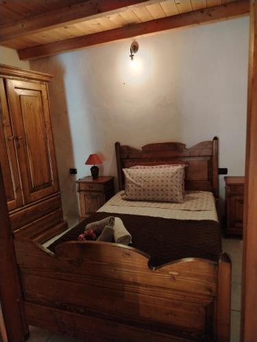 a bedroom with a wooden bed with a wooden trunk at La maison d'amour in Sanluri