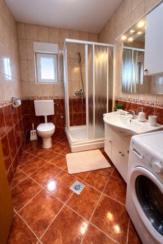 a bathroom with a toilet and a shower and a sink at Apartmani Čop Rab in Banjol