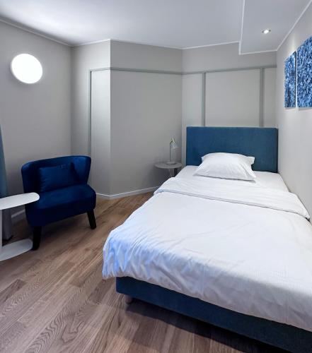 a bedroom with a bed and a blue chair at Townhouse Düsseldorf in Düsseldorf