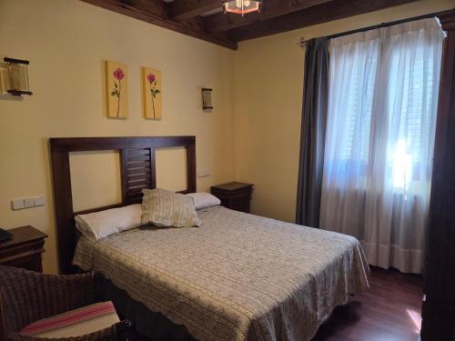 a bedroom with a bed and a large window at Hotel Rural Las Farolas in San Rafael