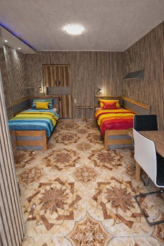 a bedroom with two beds with colorful pillows at Apartmány Fialka in Třeboň