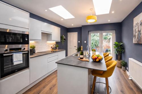 a kitchen with white cabinets and a table with fruit on it at Falklands street City centre House-Free Parking in York