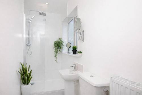 a white bathroom with a sink and a shower at Falklands street City centre House-Free Parking in York