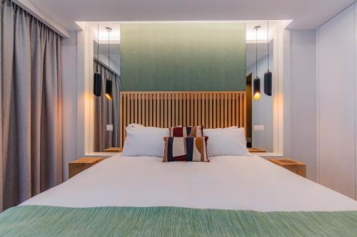 a bedroom with a large bed with white pillows at Quinta do Mar in Água de Pau