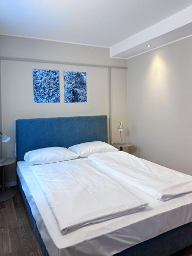 a bedroom with a bed with a blue headboard at Townhouse Düsseldorf in Düsseldorf