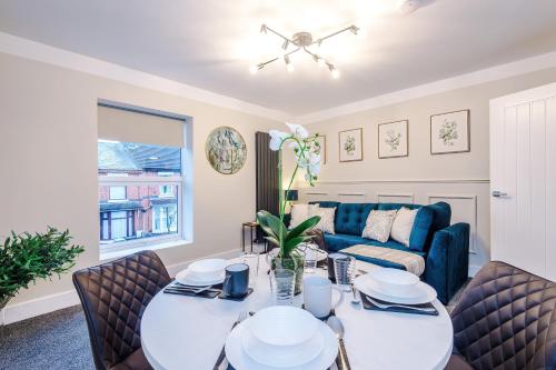 a living room with a table and chairs and a couch at Westminster Apartments by YourStays in Crewe