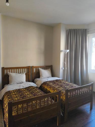 two beds sitting next to each other in a room at GLEDKA Apartament in Veliko Tŭrnovo