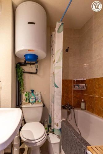 a bathroom with a toilet and a sink and a tub at Dans les mélèzes in Saint-Pancrace