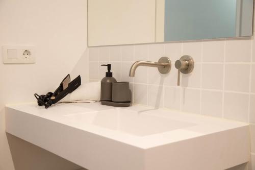 a bathroom sink with a bottle of soap and a knife at Can Turia in Valencia