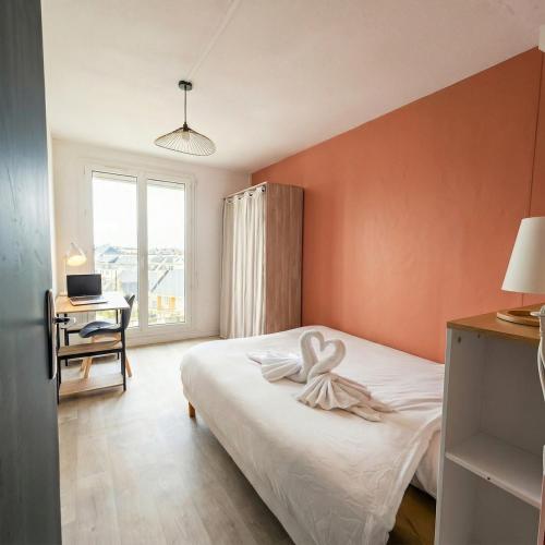 a bedroom with a bed and a desk and a window at L'Atelier Eiffel Moderne & confortable in Saint-Brieuc