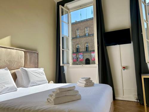 a bedroom with two beds and a window at Boboli Living in Florence