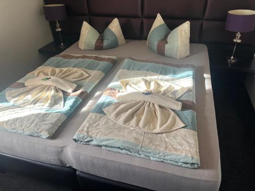 a bed with two blankets and pillows on it at Ferienwohnung Müritz-Blick in Waren