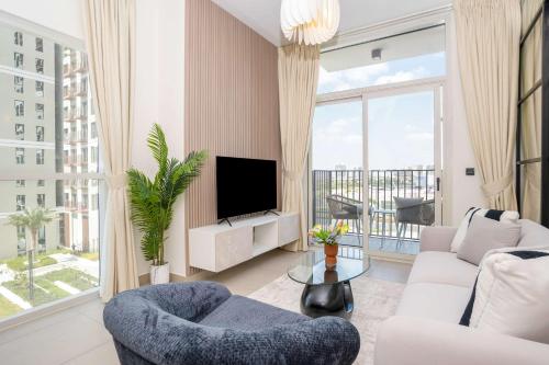 a living room with a tv and a large window at Cozy 2BR Apt in Dubai Hills in Dubai