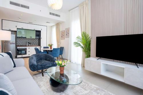 a living room with a large flat screen tv at Cozy 2BR Apt in Dubai Hills in Dubai
