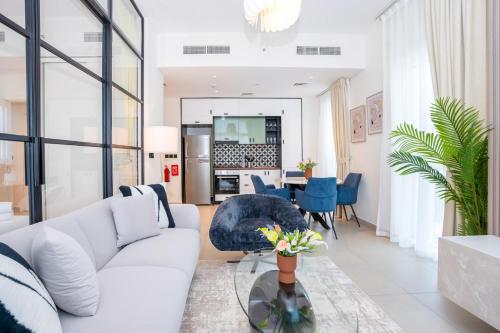 a living room with a white couch and a table at Cozy 2BR Apt in Dubai Hills in Dubai