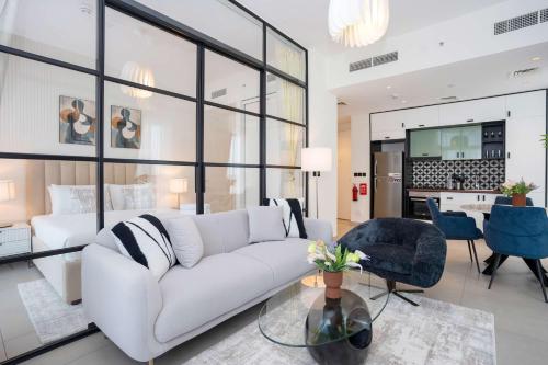 a living room with a white couch and a table at Cozy 2BR Apt in Dubai Hills in Dubai