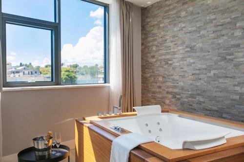 a bath tub in a bathroom with a brick wall at Marvie Hotel & Health in Split