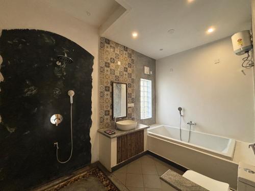 a bathroom with a bath tub and a sink at The Balified Villa in Pondicherry