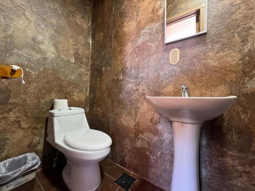 a bathroom with a toilet and a sink at Hotel de la Costa in Talcahuano
