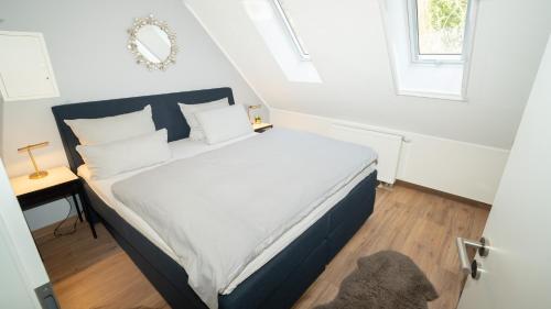 a bedroom with a large bed with white pillows at Erasmus 1901 Apartments in Trassem