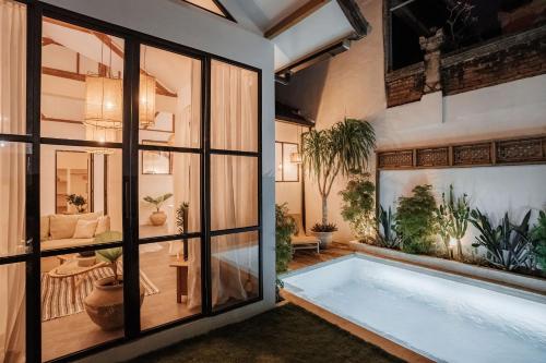 a large bath tub in a room with plants at Casa Leone Villa Canggu by Summerhouse Bali in Canggu