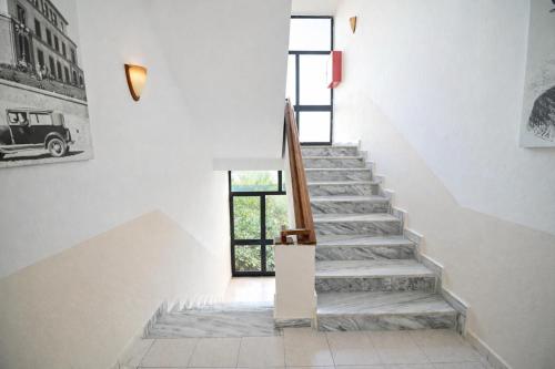 una scala in una casa con pareti bianche di Hotel Globo a Durrës