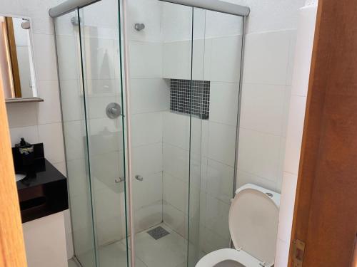 a bathroom with a glass shower with a toilet at Flats da Júnia, ótimo benefício, fácil check-in, wifi , tv, ar, garagem, localizacao in Lagoa Santa