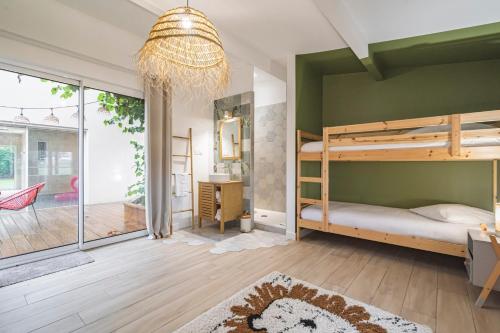 a bedroom with a green wall with bunk beds at LA VILLA PALOMA in Crécy-la-Chapelle