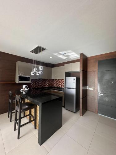a kitchen with a black counter and a refrigerator at Boat Avenue Apartment in Bang Tao Beach