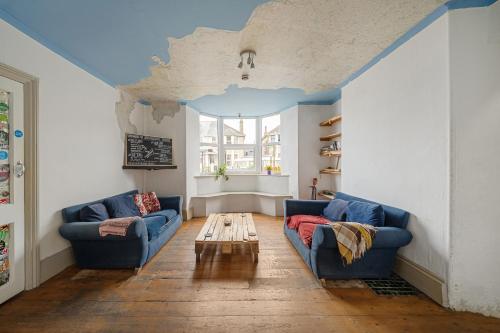a living room with two blue couches and a table at Breakwater Hostel in Newquay