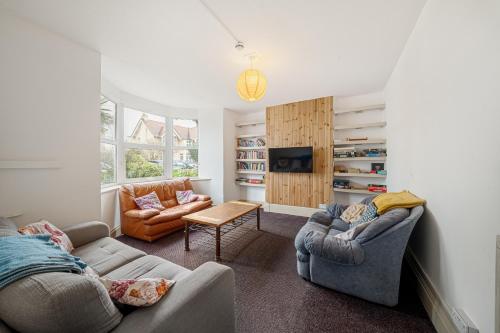 a living room with two couches and a tv at Breakwater Hostel in Newquay