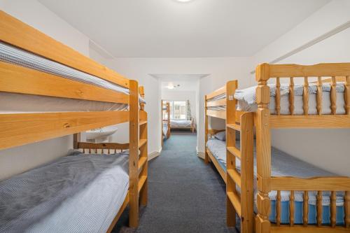 a bedroom with three bunk beds in a room at Breakwater Hostel in Newquay