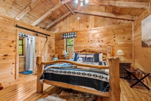 a bedroom with a bed in a log cabin at Tennessee Whisper Cabin in Sevierville