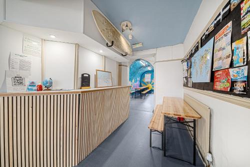 a room with a counter and a surfboard on the wall at Breakwater Hostel in Newquay