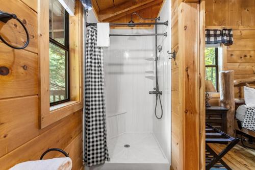 a bathroom with a shower in a wooden house at Tennessee Whisper Cabin in Sevierville