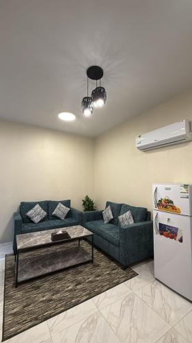 a living room with a blue couch and a refrigerator at شقق ثمانين بارك1 in Khamis Mushayt