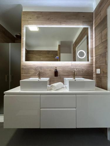 a bathroom with two sinks and a large mirror at Les Miracles du Ventoux in Malaucène