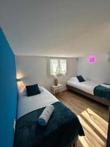 a bedroom with two beds and two windows at Les Miracles du Ventoux in Malaucène