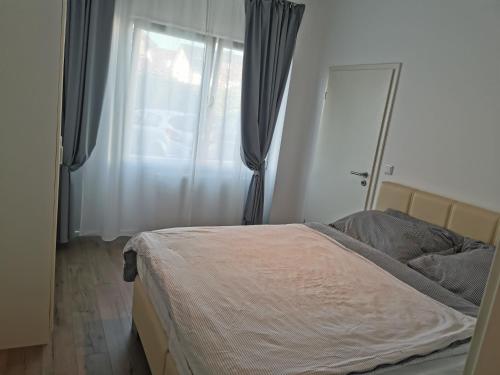 a bedroom with a bed and a window with curtains at 3 Ferienwohnungen am Teutoburger Wald in Natrup Hagen
