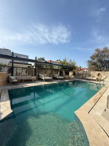 a swimming pool with blue water in a yard at Boreas Otel Alaçatı in Alaçatı