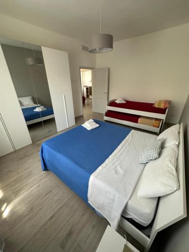 a bedroom with a blue bed and a mirror at Casa Punta d'Oro in Faccia di Trippa