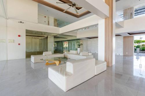 a living room with white furniture and a ceiling fan at Cozy and Nature-Inspired Studio Unit in Agus