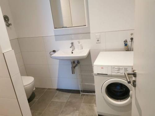 a small bathroom with a sink and a washing machine at 3 Ferienwohnungen am Teutoburger Wald in Natrup Hagen
