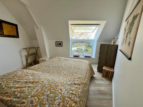 a bedroom with a bed and a window at L'Erable - Maison vue mer in Donville-les-Bains