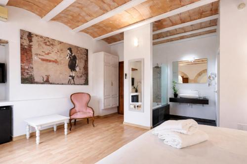 ein Schlafzimmer mit weißen Wänden und einer Holzdecke in der Unterkunft Hotel Can Riera by CheelHotels in Moscari