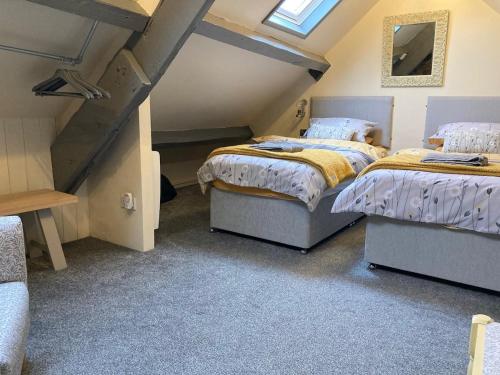 a attic bedroom with two beds and a window at The Studio Gressingham in Hornby