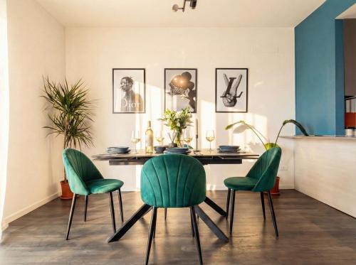 a dining room with a table and four green chairs at Design Penthouse with Balcony - Iseo in Iseo