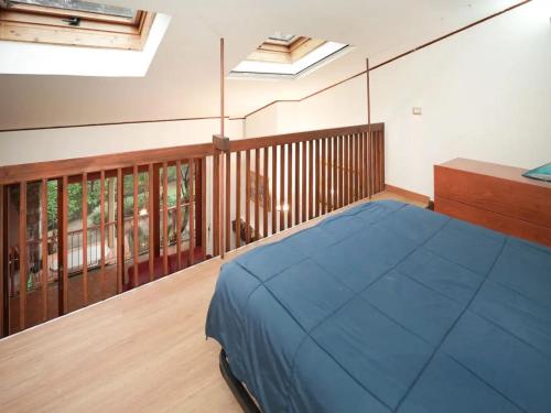 a bedroom with a blue bed and a balcony at Parco Hermitage - Villa Azalea in Porto Valtravaglia
