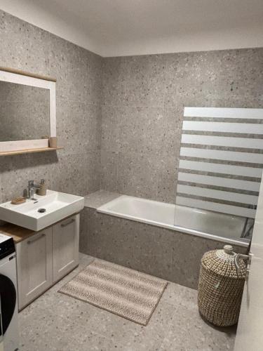 a bathroom with a bath tub and a sink at Lima Apartment in Bernolákovo