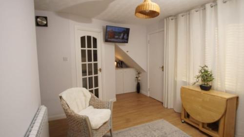a living room with a chair and a desk at Cosy flat in Inverness